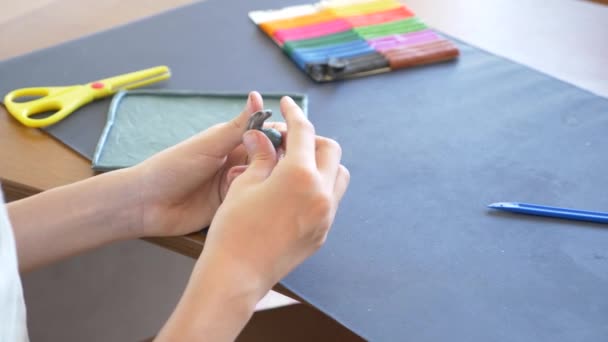 A menina sentada à mesa, desenha figuras diferentes da plasticina de modelo a cores. Desenvolvimento de modelagem de arte em crianças. 4k, close-up, câmera lenta — Vídeo de Stock