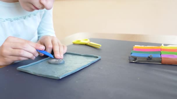 La fille assise à la table, dessine différentes figures de la plasticine de modèle de couleur. Développement de la modélisation artistique chez les enfants. 4k, gros plan, ralenti — Video