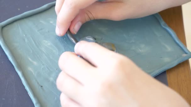 A menina sentada à mesa, desenha figuras diferentes da plasticina de modelo a cores. Desenvolvimento de modelagem de arte em crianças. 4k, close-up, câmera lenta — Vídeo de Stock