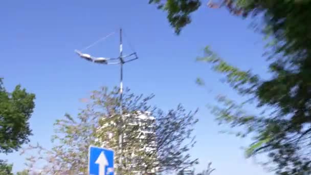 A vista da janela de um carro que cavalga ao longo do beco florido da cidade. 4k, câmera lenta — Vídeo de Stock