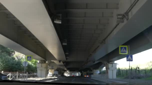 Verkeer onder een viaduct in de stad. 4k, slow-motion — Stockvideo