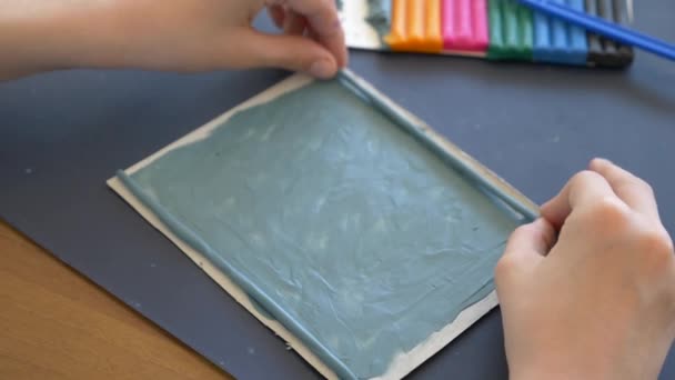 Dívka sedí u stolu, nakreslí různé postavy z plastelíny barevný model. Vývoj umění modelování u dětí. 4 k, close-up, pomalý pohyb — Stock video