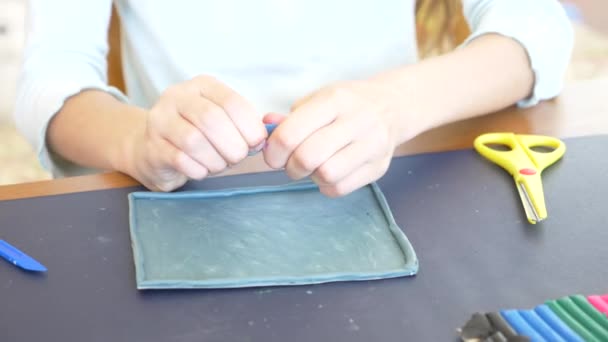 Dívka sedí u stolu, nakreslí různé postavy z plastelíny barevný model. Vývoj umění modelování u dětí. 4 k, close-up, pomalý pohyb — Stock video
