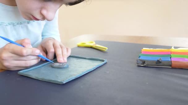坐在桌边的女孩从颜色模型橡皮泥画出不同的数字。儿童艺术造型的发展。4k、特写、慢动作 — 图库视频影像