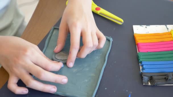 La fille assise à la table, dessine différentes figures de la plasticine de modèle de couleur. Développement de la modélisation artistique chez les enfants. 4k, gros plan, ralenti — Video