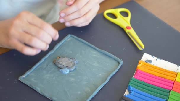 坐在桌边的女孩从颜色模型橡皮泥画出不同的数字。儿童艺术造型的发展。4k、特写、慢动作 — 图库视频影像