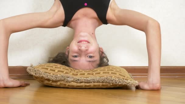 Chica divertida haciendo flexiones al revés en casa. 4k. retrato de una chica de pie boca abajo — Vídeos de Stock