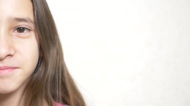 Neşeli bir kız kameraya benziyor. 4 k. yakın çekim yarım yüz, yakın çekim. kopyalama alanı