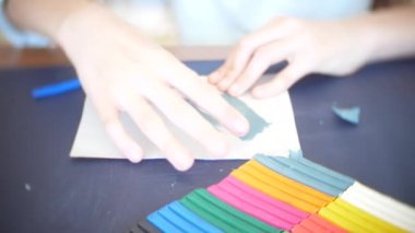 masada oturan kız farklı renk model hamuru rakamları çizer. Çocuklarda modelleme sanat kalkınma. 4k, yakın çekim