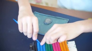 masada oturan kız farklı renk model hamuru rakamları çizer. Çocuklarda modelleme sanat kalkınma. 4k, yakın çekim