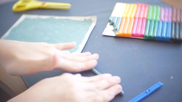 La fille assise à la table, dessine différentes figures de la plasticine de modèle de couleur. Développement de la modélisation artistique chez les enfants. 4k, gros plan — Video