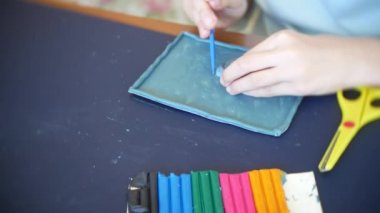 masada oturan kız farklı renk model hamuru rakamları çizer. Çocuklarda modelleme sanat kalkınma. 4k, yakın çekim