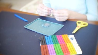 masada oturan kız farklı renk model hamuru rakamları çizer. Çocuklarda modelleme sanat kalkınma. 4k, yakın çekim