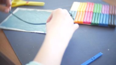 masada oturan kız farklı renk model hamuru rakamları çizer. Çocuklarda modelleme sanat kalkınma. 4k, yakın çekim