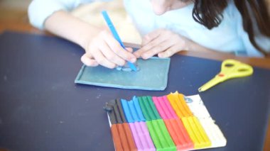 masada oturan kız farklı renk model hamuru rakamları çizer. Çocuklarda modelleme sanat kalkınma. 4k, yakın çekim