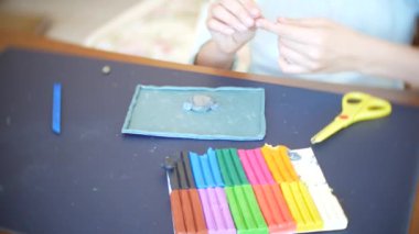 masada oturan kız farklı renk model hamuru rakamları çizer. Çocuklarda modelleme sanat kalkınma. 4k, yakın çekim