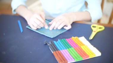 masada oturan kız farklı renk model hamuru rakamları çizer. Çocuklarda modelleme sanat kalkınma. 4k, yakın çekim
