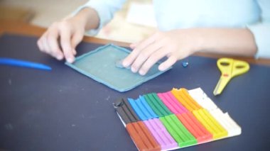 masada oturan kız farklı renk model hamuru rakamları çizer. Çocuklarda modelleme sanat kalkınma. 4k, yakın çekim