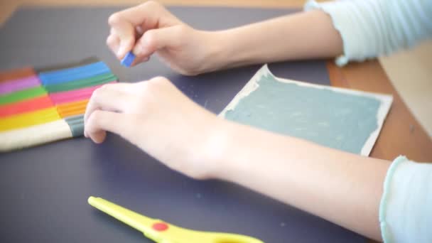 A menina sentada à mesa, desenha figuras diferentes da plasticina de modelo a cores. Desenvolvimento de modelagem de arte em crianças. 4k, close-up — Vídeo de Stock