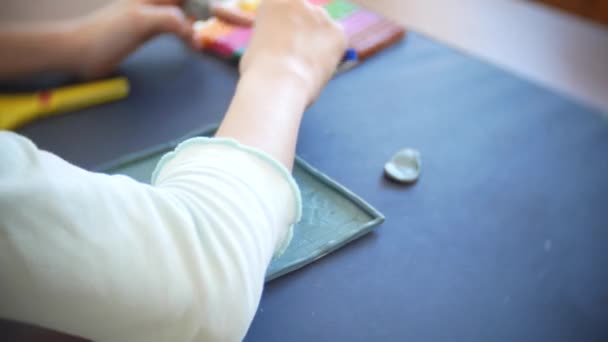 Flickan sitter vid bordet, ritar olika siffror från färg modell Plastilina. Utvecklingen av konst modellering i barn. 4k, närbild — Stockvideo