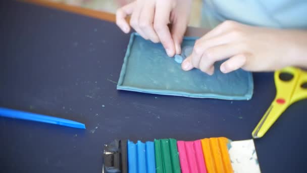 Дівчина сидить за столом, малює різні фігури з пластиліну кольорової моделі. Розвиток художнього моделювання у дітей. 4k, крупним планом — стокове відео