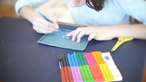 Το κορίτσι που κάθεται στο τραπέζι, αντλεί διαφορετικούς αριθμούς από χρώμα μοντέλο πλαστελίνη. Ανάπτυξη της τέχνης μοντελοποίηση στα παιδιά. 4k, γκρο πλαν — Αρχείο Βίντεο