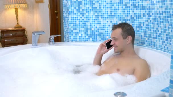 Ein junger Mann wirft beim Baden ein Handy ins Wasser — Stockvideo