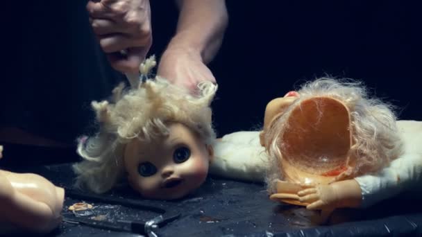 Mãos masculinas cortadas a cabeça de uma boneca velha. Conceito de Halloween, violência, maníaco — Vídeo de Stock
