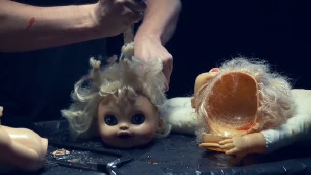 Mãos masculinas cortadas a cabeça de uma boneca velha. Conceito de Halloween, violência, maníaco — Vídeo de Stock