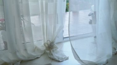 Kedi perdeleri olan camdan bir kapıdan içeri girer..