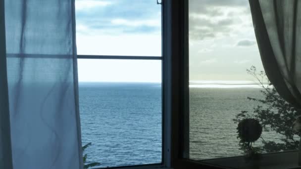 Transparenter Vorhang am Fenster mit Blick auf das Meer, sanft vom Wind bewegt. Sonnenlicht. — Stockvideo