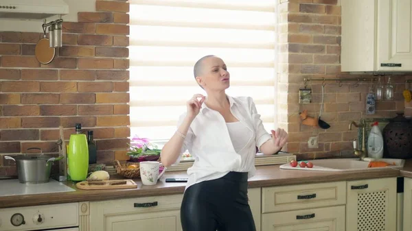 Medium shot. young amazingly emotional bald woman dancing in the kitchen at home — Stock Photo, Image