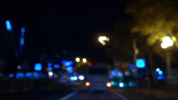 Розмитий фон. вид з вікна автомобіля з розмитим освітленням міського руху на вулицях міста вночі — стокове фото