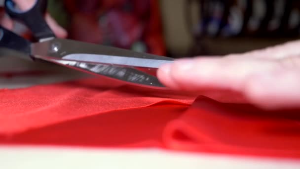 Close-up. male tailors hands cut red fabric with scissors — Stock Video