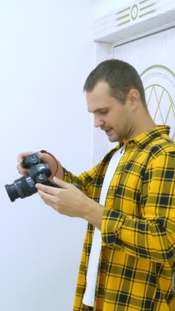 Genç yakışıklı fotoğrafçı dişçi kliniğinde fotoğraf çekiyor. İş yerinde profesyonel fotoğrafçı. dikey çekim — Stok video