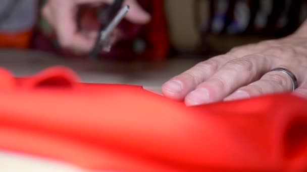 남자 손 이 가위붉은 천을 잘랐다. 디자인 과 맞춤의 개념입니다. 슈퍼 클로즈업. — 비디오