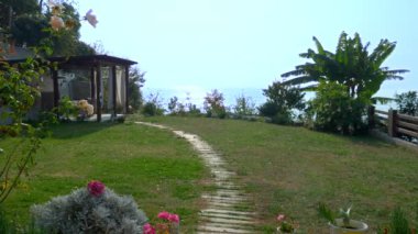 arka plan doğası. Bir çardak ve deniz kenarındaki çimenlikte ona giden yol.