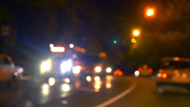 Wazige achtergrond. 's Nachts auto' s verplaatsen in een straat. verlichtingssterkte — Stockvideo