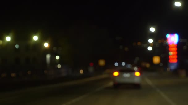 Fondo borroso. moviendo coches en una calle de la ciudad por la noche. iluminaciones — Vídeos de Stock