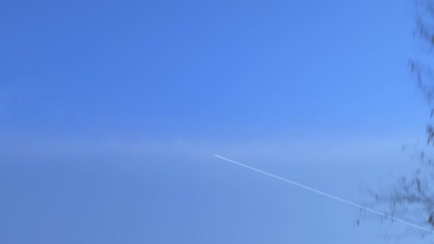 O traço do avião no céu. a vista da janela de um carro em movimento — Vídeo de Stock