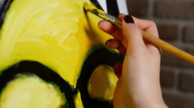 Ressam, tuvaldeki yağlı boyaya neden olur. siyah ve sarı desen