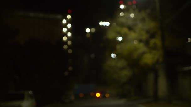 Θολό φόντο. Μετακίνηση αυτοκινήτων σε ένα δρόμο της πόλης τη νύχτα. φωτισμοί — Αρχείο Βίντεο