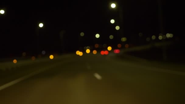 Latar belakang kabur. memindahkan mobil di jalan kota pada malam hari. iluminasi — Stok Video