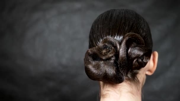 Mince fille brune avec coiffure élégante sur un fond noir — Video