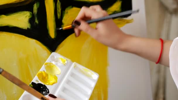 Primer plano, el artista causa la pintura al óleo en el lienzo. patrón negro y amarillo — Vídeo de stock