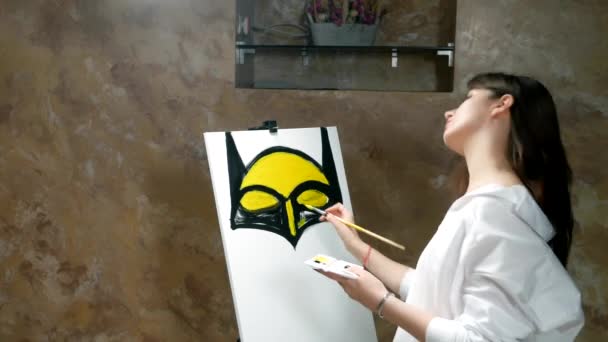 Beautiful sexy girl artist paints a picture on canvas in the loft — Stockvideo