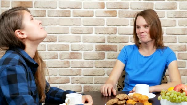 Лесбійська сім'я п'є чай вдома. проти цегляної стіни — стокове відео