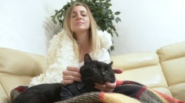  Kız, siyah bir kediyi gömlekle okşuyor. Kedisi olan güçlü, kendine yeten bir kadın.