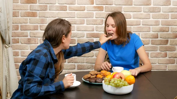 Lesbian family drinking tea at home . against a brick wall — Stock Photo, Image