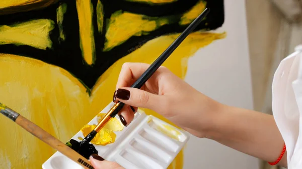Zbliżenie, artysta powoduje farbę olejną na płótnie. czarny i żółty wzór — Zdjęcie stockowe